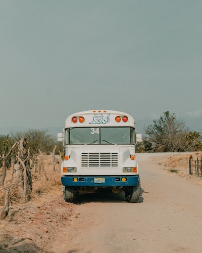 During the day, on a brown field under the blue sky blue and white truck
